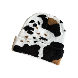 Vintage cow print knitted beanie in black and white pattern for autumn winter warmth