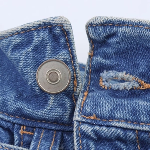 Gros plan d'un short en jean avec bouton métallique et coutures en sergé détaillées