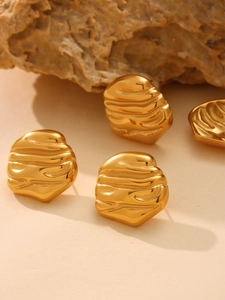 Detailed view of gold irregular geometric stud earrings with rippled texture on stone