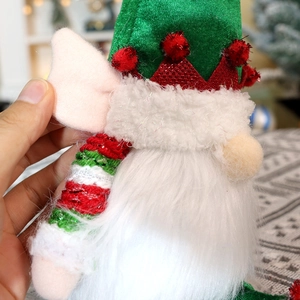 Macro detail of Christmas gnome showing green felt hat and plush white beard texture