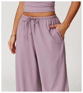 Detail of high-waisted lilac wide-leg pants with elastic drawstring and side pockets