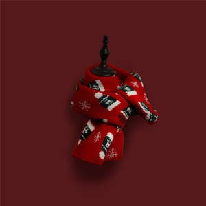Detailed view of red Christmas knit scarf with white snowflake and snowman patterns