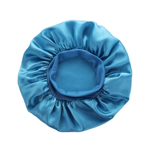 Detail of a shiny blue satin sleep bonnet with elastic wide band for hair protection