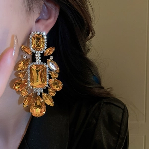 Primo piano di modella con orecchini a goccia color ambra con accenti di strass di lusso