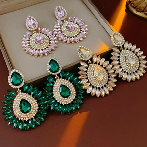 Macro detail of geometric drop earrings in pink, green and champagne crystal sunflower design
