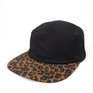 Detail view of the black 5-panel cap featuring a leopard print brim and metal eyelets