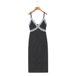 Detailed view of V-neckline with white lace trim on a French black polka dot midi dress