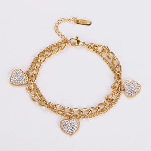 Close-up of golden double-layer steel bracelet with heart charms and white sparkling crystals