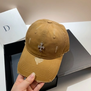 Macro detail of khaki distressed cotton baseball cap with silver metal cross emblem