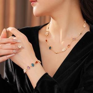 Gros plan d'un ensemble de bijoux vintage dorés avec pierres colorées sur un mannequin