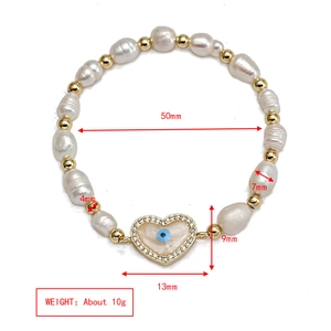 Close-up of beaded evil eye heart bracelet with baroque pearls and size measurements