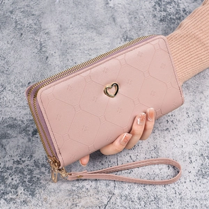 Pink double zipper long wallet with heart hardware and wristlet on marble background