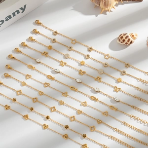 Close-up of assorted gold titanium steel bracelets with star, heart and clover charms