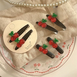 Set of 4 cute cherry hair clips with red glitter finish on cozy aesthetic background
