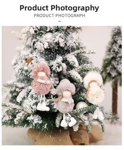 Close-up of three plush Christmas angel dolls with hats and scarves on a snowy tree