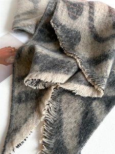 Gros plan d'une écharpe à imprimé léopard gris avec texture douce et détails à franges