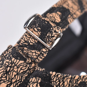 Macro shot of silver adjustable buckle on black and gold lace jacquard strap texture