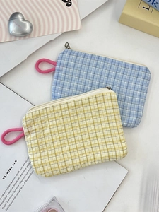 Plaid canvas zipper coin pouches in blue and yellow with pink wrist straps on a desk