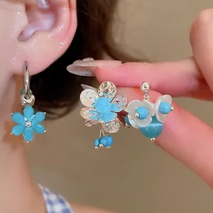 Blue flower earring necklace set with silver accents and elegant pearls on ear