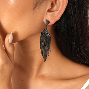 Close-up of black beaded tassel earrings on model showing elegant dark gothic fringe style