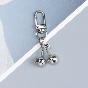 Detailed view of silver metal cherry keychain with a polished finish and lobster clasp
