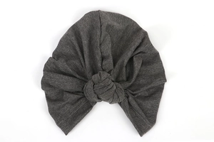 Detail view of the fine knitted texture and dark grey fabric of the elastic turban hat
