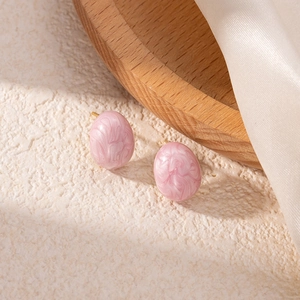 Elegant pink marble oval titanium stud earrings on minimalist aesthetic background