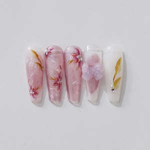 Pink floral press-on nails with 3D bows, pearls and Japanese lettering on white background