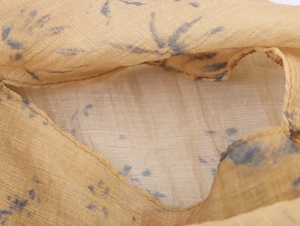 Detail of yellow floral chiffon fabric with blue prints and fine sewing craftsmanship