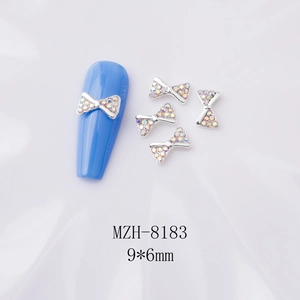 Nœud argenté pour nail art avec strass AB, 9x6mm, présenté sur faux ongles bleus