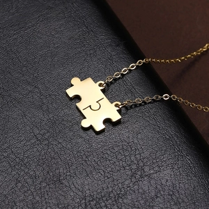 Macro shot of gold puzzle piece pendants on textured black leather background