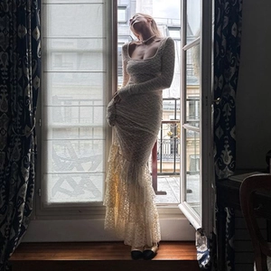 Elegant beige lace two-piece set featuring long-sleeve sheer top and fishtail maxi skirt