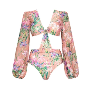 Detail of floral one-piece swimsuit with long lantern sleeves and waist cut-outs