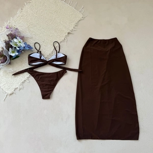 Mise à plat d'un ensemble bikini marron chocolat trois pièces avec jupe de plage assortie