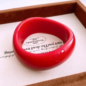 Gros plan d'un bracelet en acrylique rouge sur un plateau avec éclairage doux