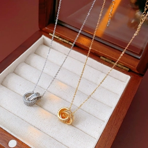 Detailed view of intertwined 18K gold and silver circles with pavé zircon in a jewelry box