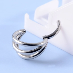 Detailed macro view of triple-layered silver hinged hoop ring body piercing jewelry