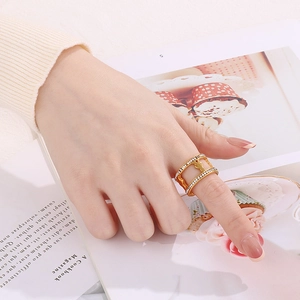 Close-up of a double-layered gold cactus ring with sparkling white zircons on finger
