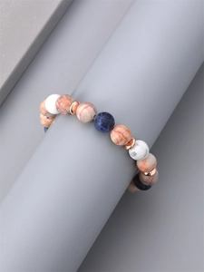 10mm blue and orange natural stone beaded bracelet on a minimalist grey pedestal