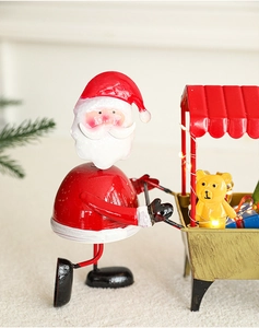 Détail du chariot de Noël illuminé en fer forgé avec Père Noël et boîtes cadeaux