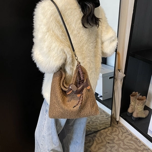 Brown fuzzy fleece tote bag with leather dachshund charm shown on shoulder for daily commute