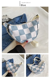 Detail shot of the blue and white checkerboard knit pattern on a crescent-shaped bag