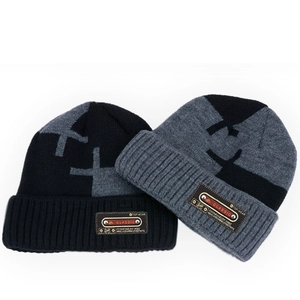 Detail view of winter knitted beanie hats with fleece lining and classic leather patch