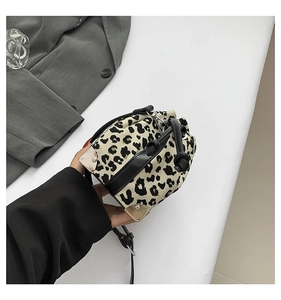 Detailed view of leopard print bucket bag featuring gold metal corners and leather drawstring
