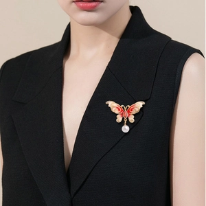 Elegant red enamel butterfly brooch with gold plating and pearl drop on black top