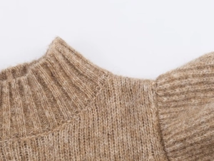 Macro detail of khaki wool knit fabric showing ribbed neckline texture and soft fibers