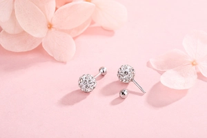 Detail view of S925 sterling silver pave disco ball earrings with screw back on pink floral