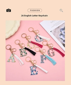 Detail shot of floral alphabet keychains A-G with matching color tassels and gold hardware