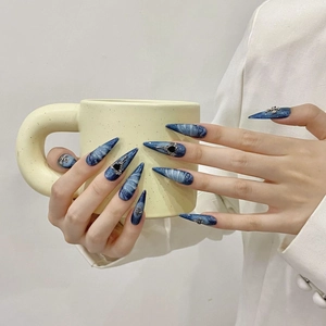 Blue ocean style press-on nails with silver cross and heart charms on almond shape