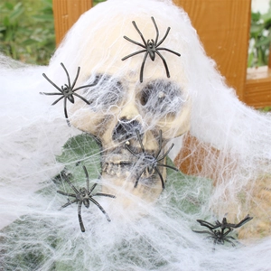Close-up of Halloween spider web with skulls and small black plastic spiders for decor